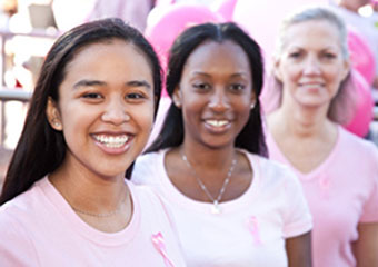 three women with pink shirts on
