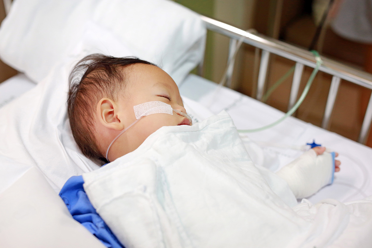 sick infant in a hospital bed