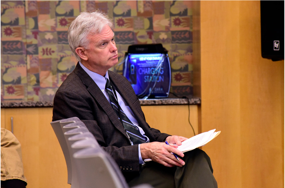 B. Alex Merrick, Ph.D. listens while seated