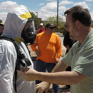 A trainer at the IBT 2019 CER course explained proper use of PPE to a participant.