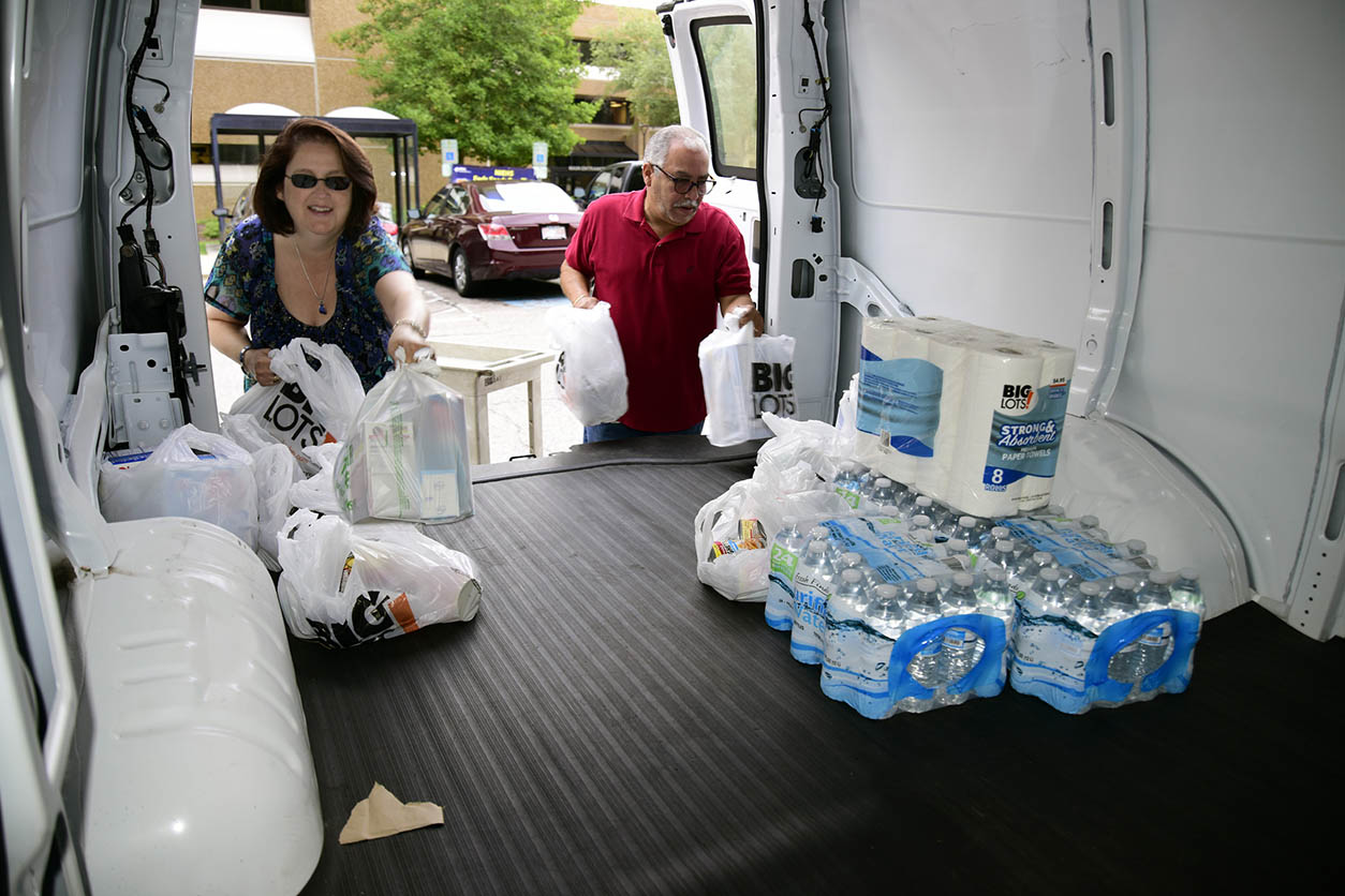 Tonya McMillan and Benny Encarnacion placing donations in van