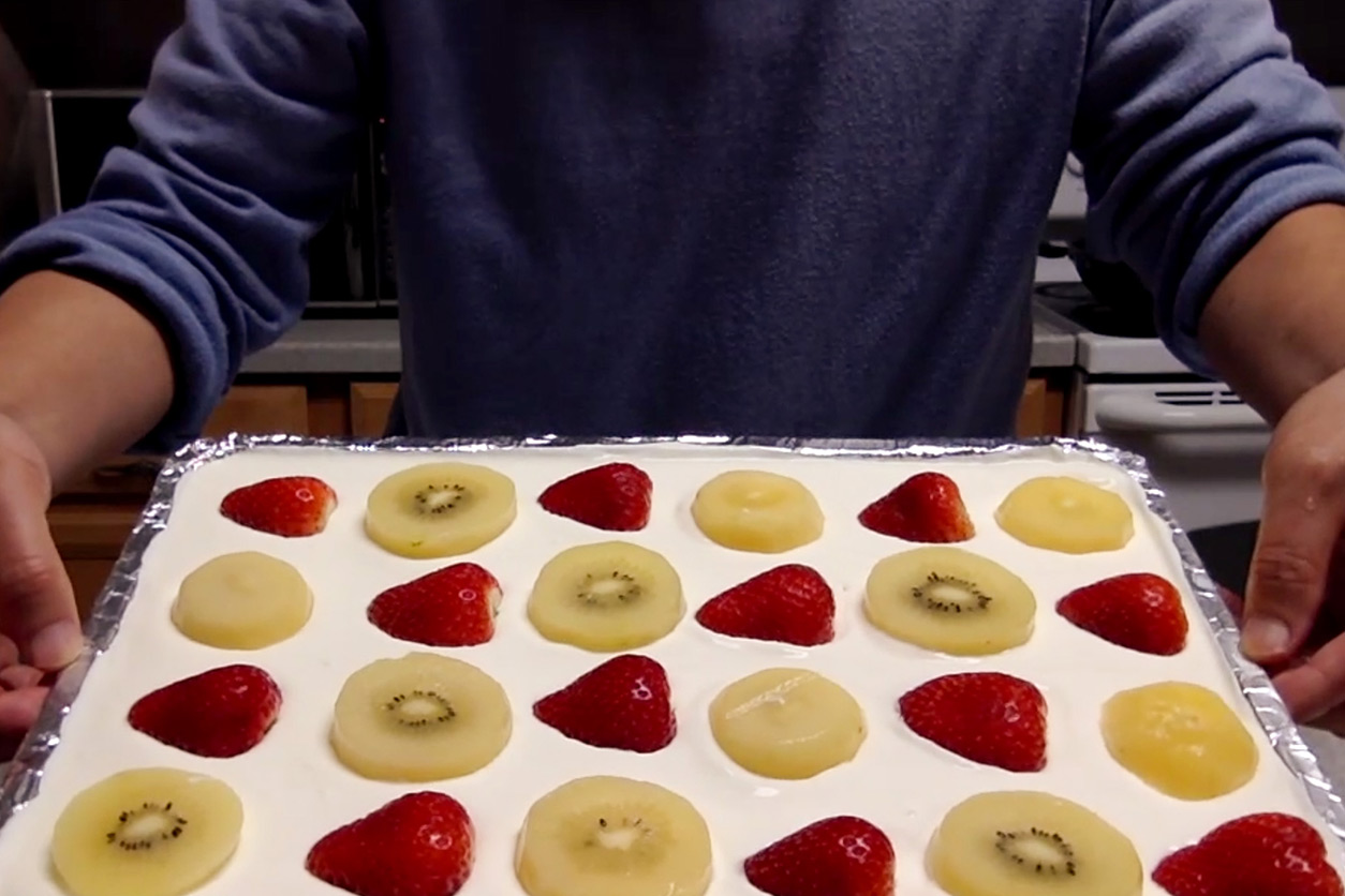 tray of sliced strawberries and kiwi