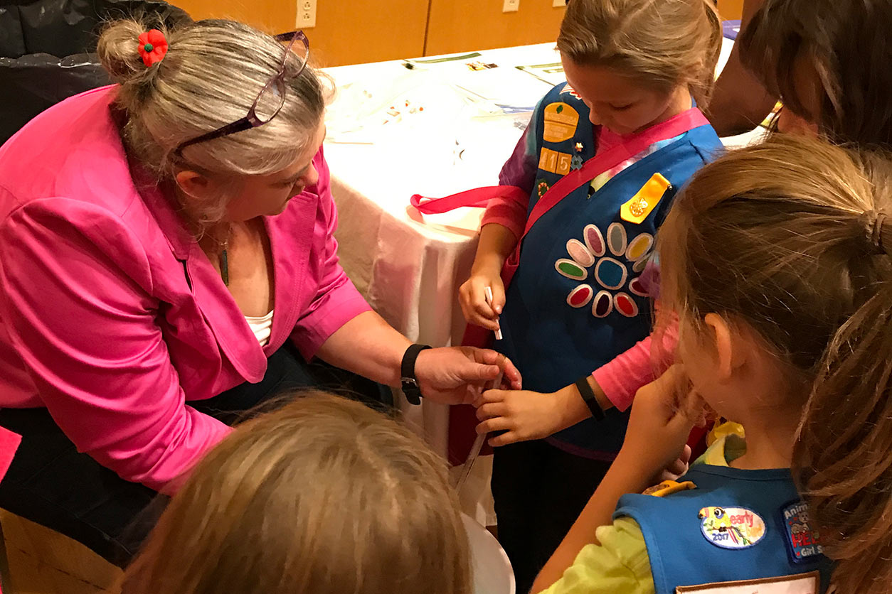 Christie Drew, Ph.D. shares a lung capacity demonstration with Girl Scouts