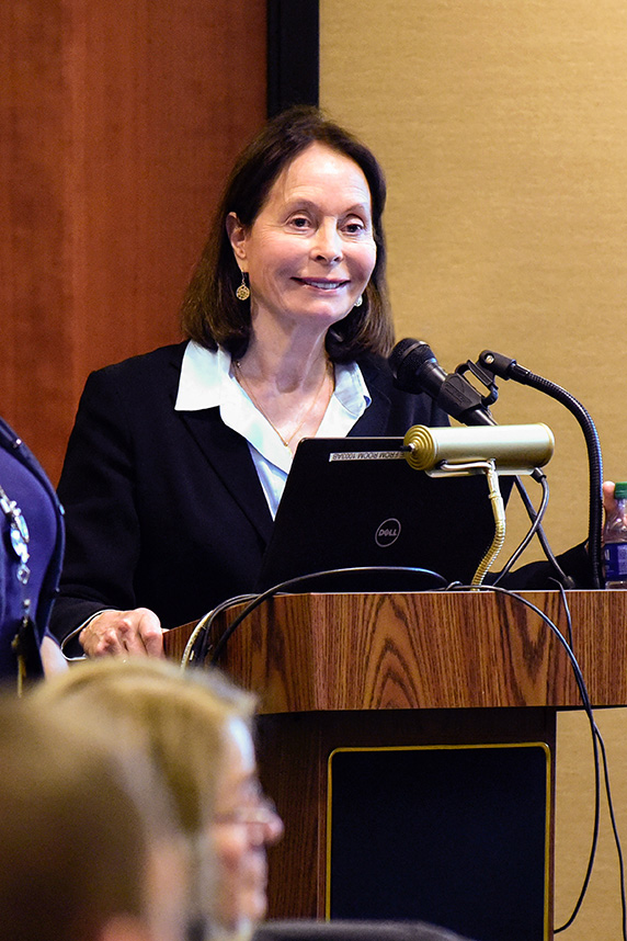 Frederica Perera, Ph.D. stands at podium