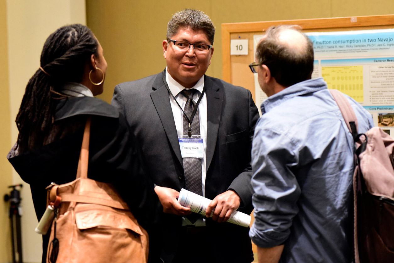Tommy Rock, Ph.D. speaks with meeting attendees