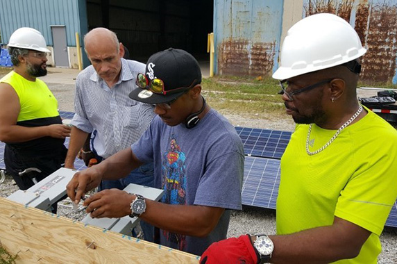 Trainees learning how to install solar panels