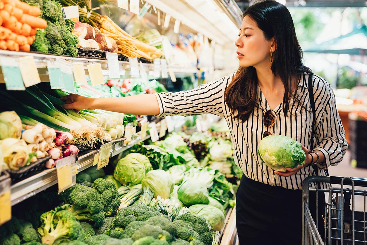 woman looking at vegetables in a grocery store