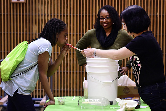 girl and scientists doing a lung capacity demonstration