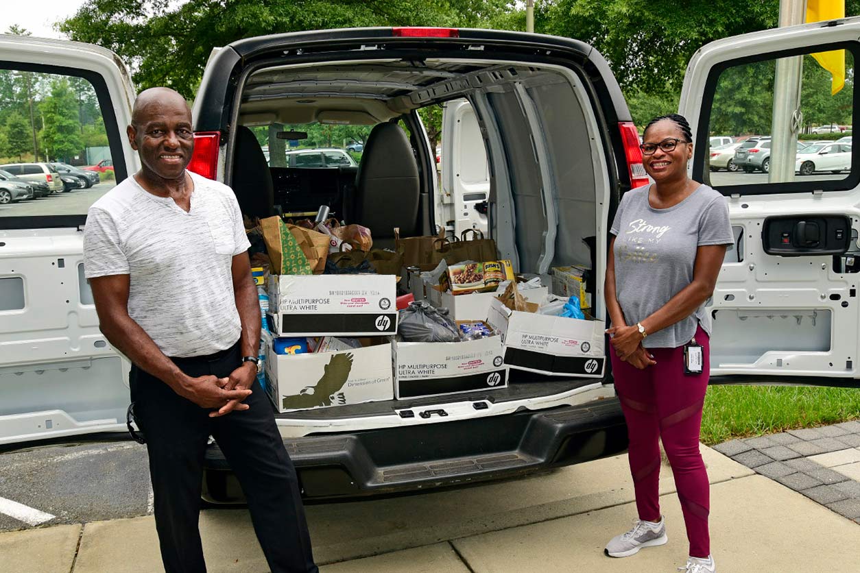 Wilder and Brace pose next to the van-full of donated food items