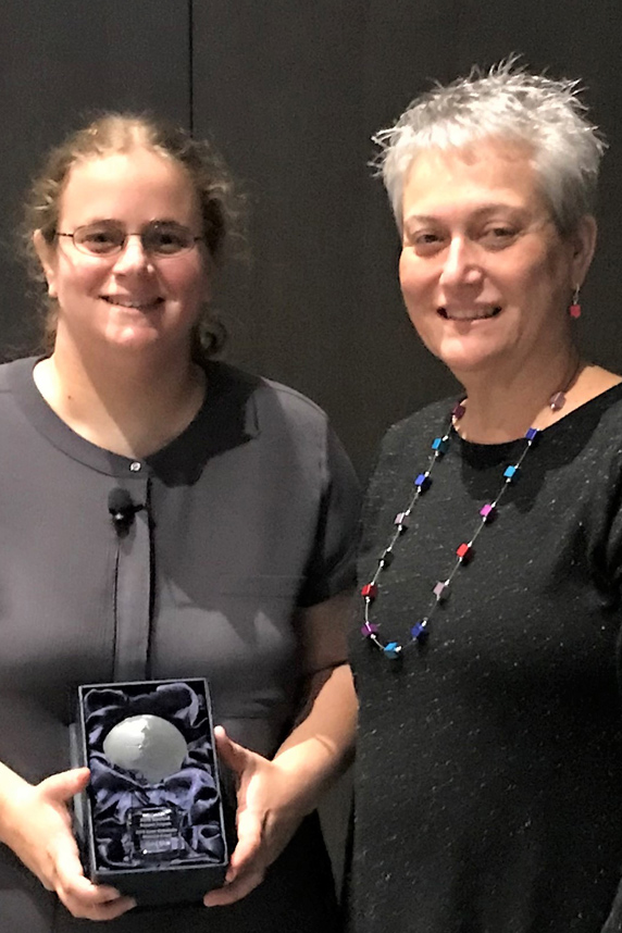Elana Elkin, Ph.D. holds annual Karen Wetterhahn Memorial Award and stands with Gwen Collman, Ph.D.