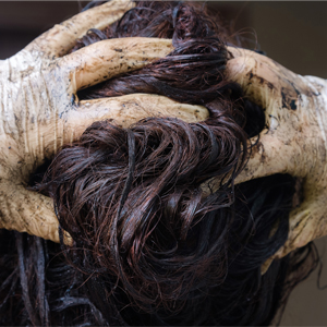 woman with gloved hands running fingers through hair and gloves coated with hair dye