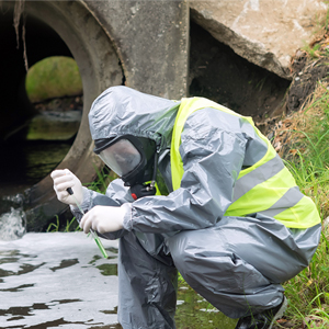 person in protective suit taking a water sample