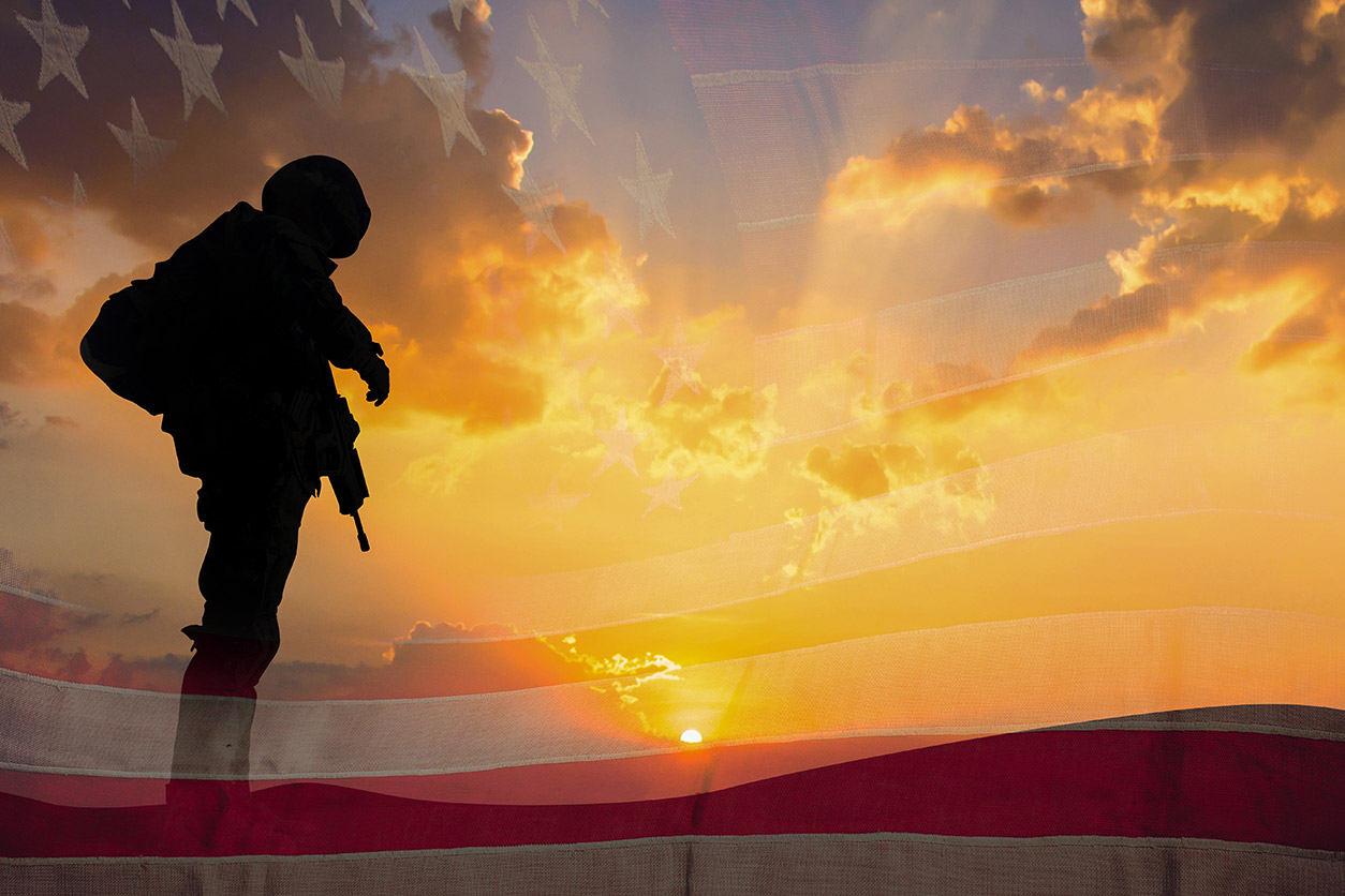 silhouette of a soldier on U.S. flag during sunset