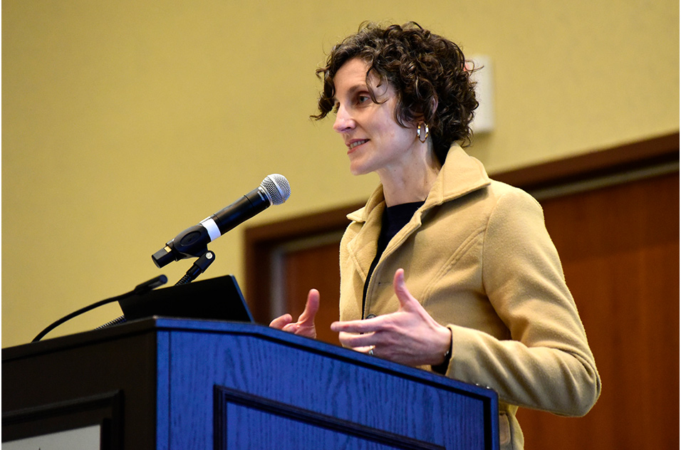 Virginia Guidry, Ph.D. stands at podium