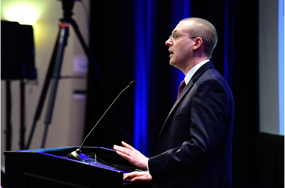 Chris Duncan, Ph.D. stands at podium