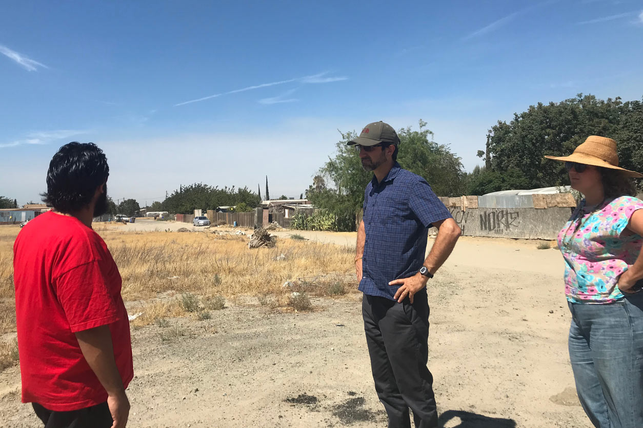 Miguel Alatorre gives a tour of Kettleman City to Jonathan London, and Aubrey Thompson