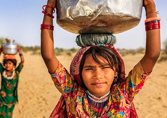 women carrying water jugs on their head