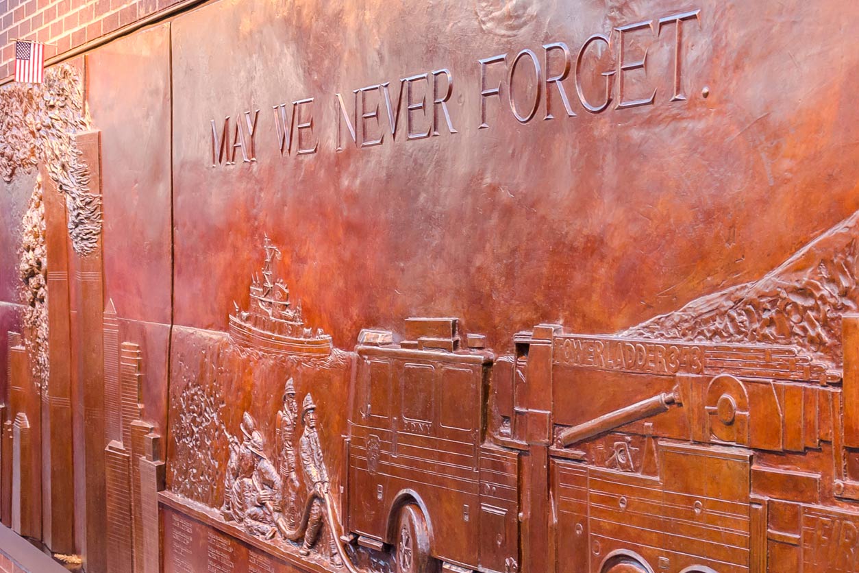 May We Never Forget etched on a bronze mural, New York City