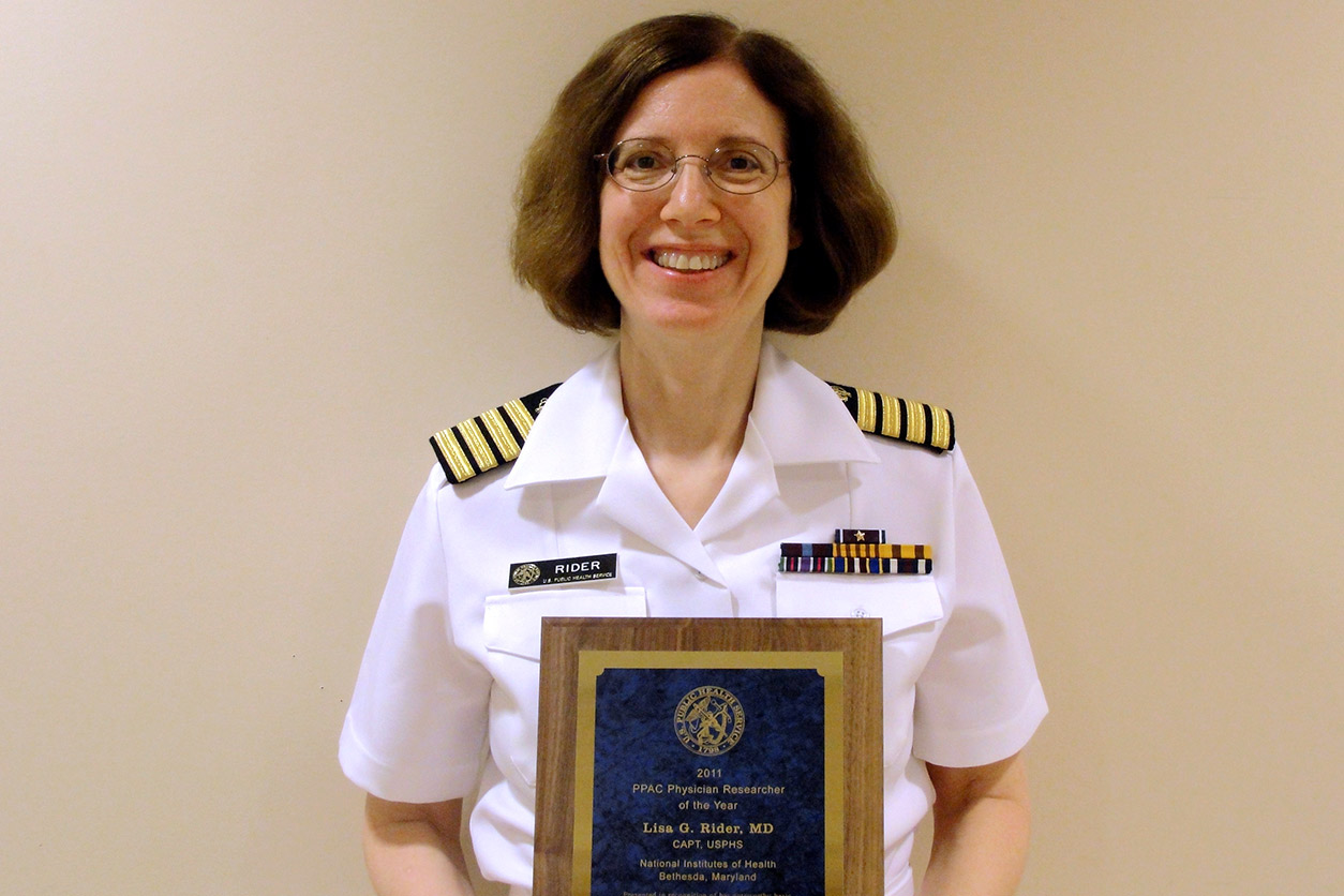 Lisa Rider holds her 2011 Physician Researcher of the Year Award