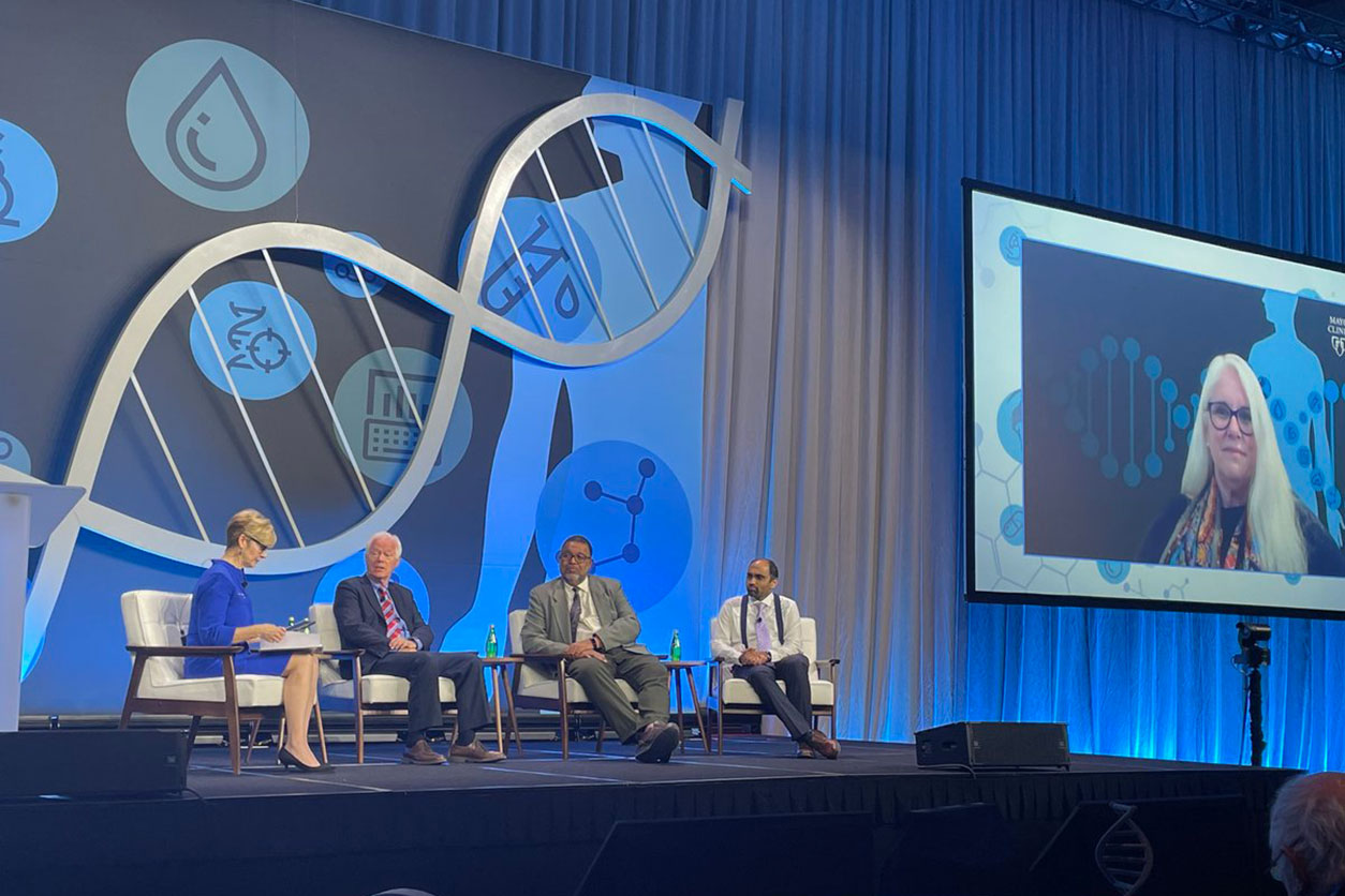 A hybrid panel discussion featured (left to right) Wurzer, Archer, the Mayo Clinic’s Arjun Athreya, Ph.D.; Jones, and Sumner on the big screen.