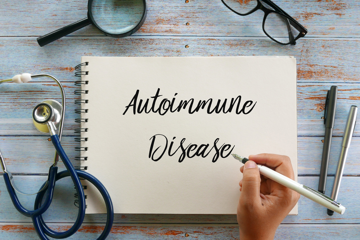 Autoimmune disease written on a notepad with a stethoscope and magnifying glass nearby