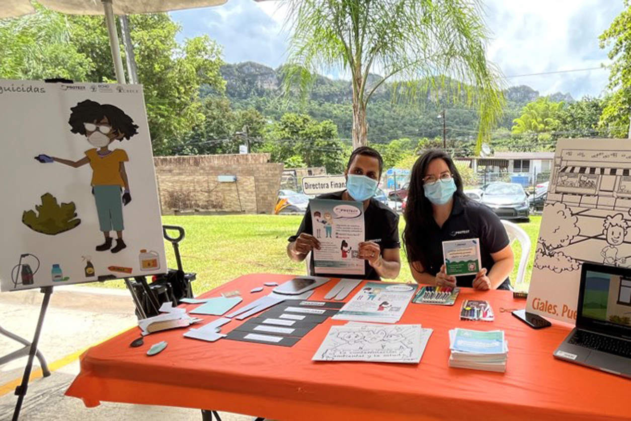 PROTECT trainees Nobel Hernández and Amailie Santos present educational materials at a community engagement event 