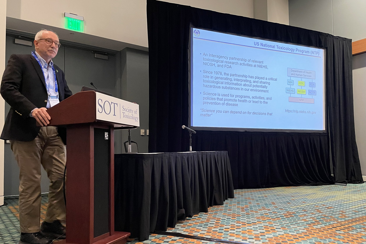 Rick Woychik, Ph.D. in front of big screen presenting at SOT