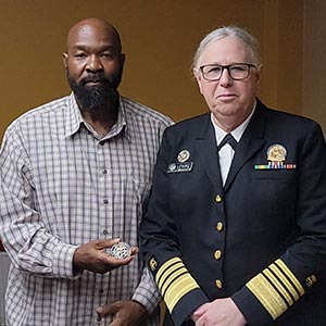 Admiral Rachel Levine, M.D., presents presented Tristan Mack, a worker training program success story, with the U.S. Public Health Service Coin.