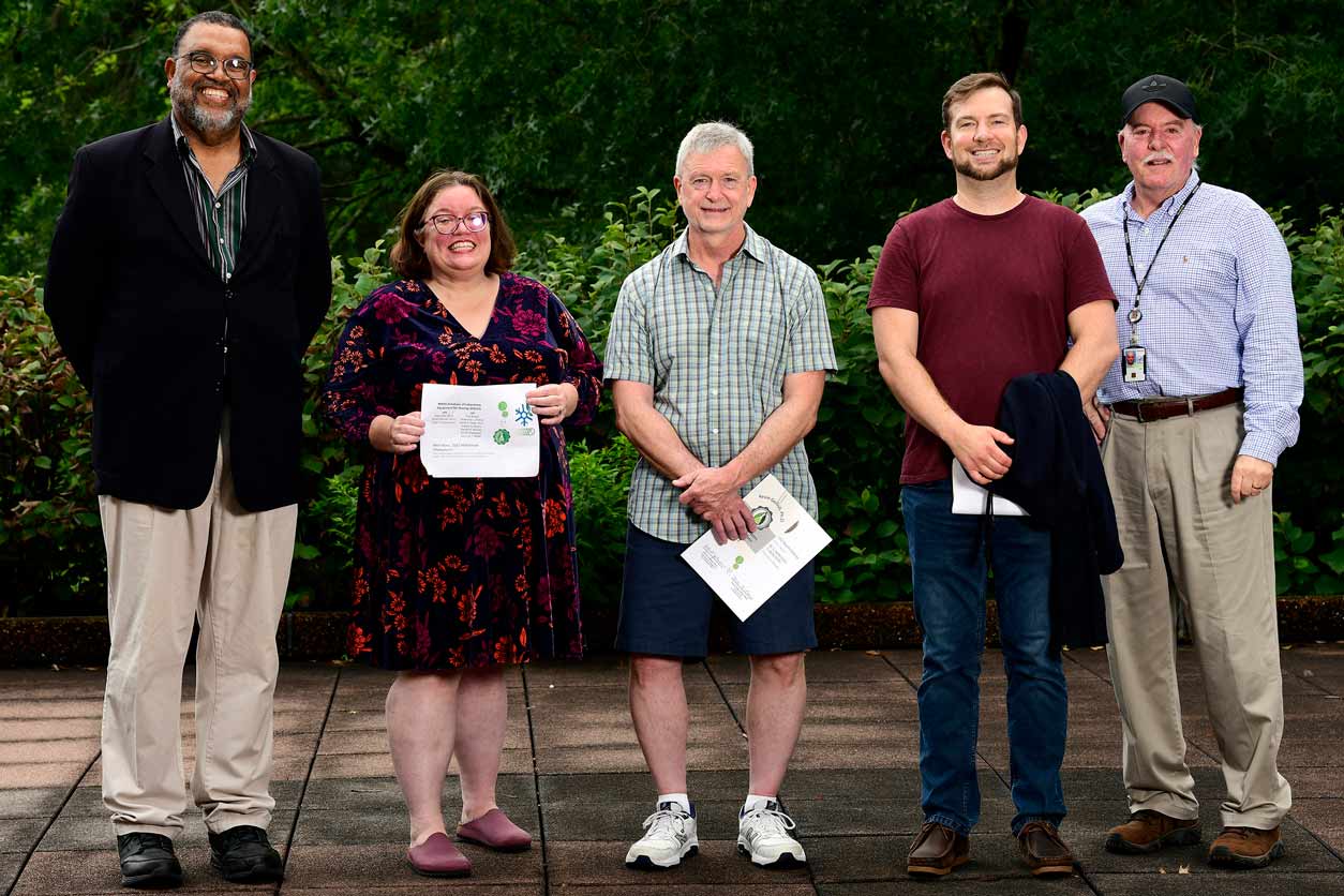 Deputy Director Trevor Archer, Ph.D., poses for a photo with DOLES awardees who were present at the ceremony