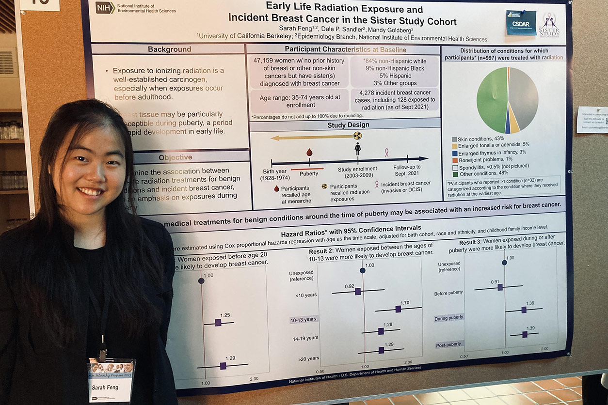 Sarah Feng stands before her poster on early life radiation exposure and incident breast cancer.