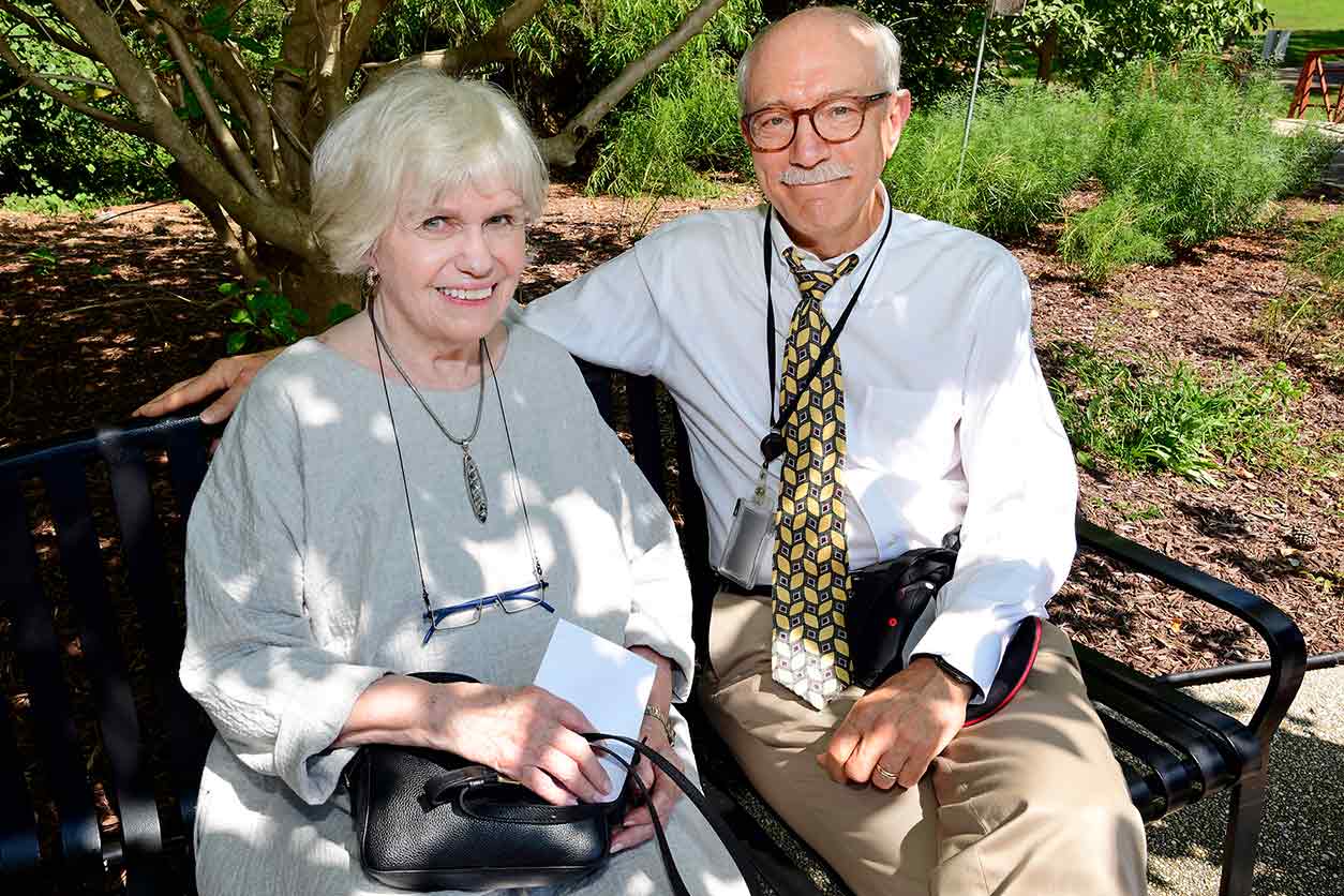 Dorothea Wilson and NIEHS Director Rick Woychik, Ph.D., sitting on the Sam Wilson Jr., M.D., memorial bench