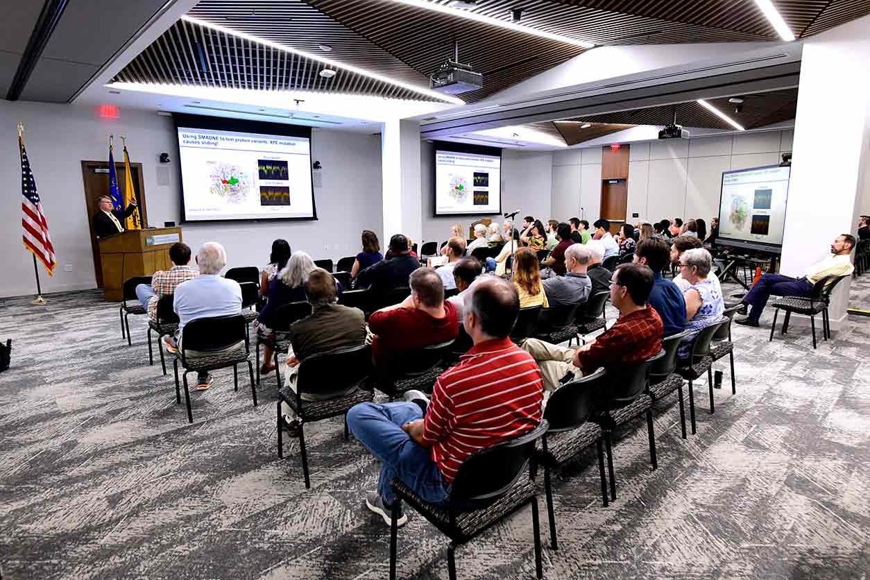 Attendees in conference room for the hybrid event