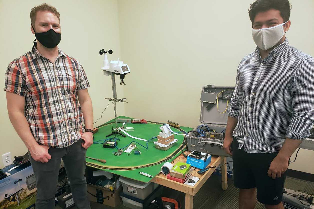 Nicholas Spada, Ph.D., left, and Dhawal Majithia, right, with model trains they used to develop and test computer vision systems that can track real-life trains.