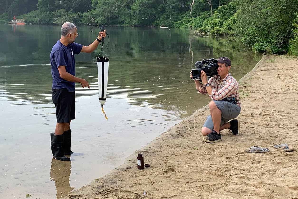 Ollie Becker with Circuit Films captures Neel Aluru, Ph.D., collecting algal samples at Coonamessett Pond in Falmouth, Mass. (Photo courtesy of Mindy Richlen / WHCOHH)