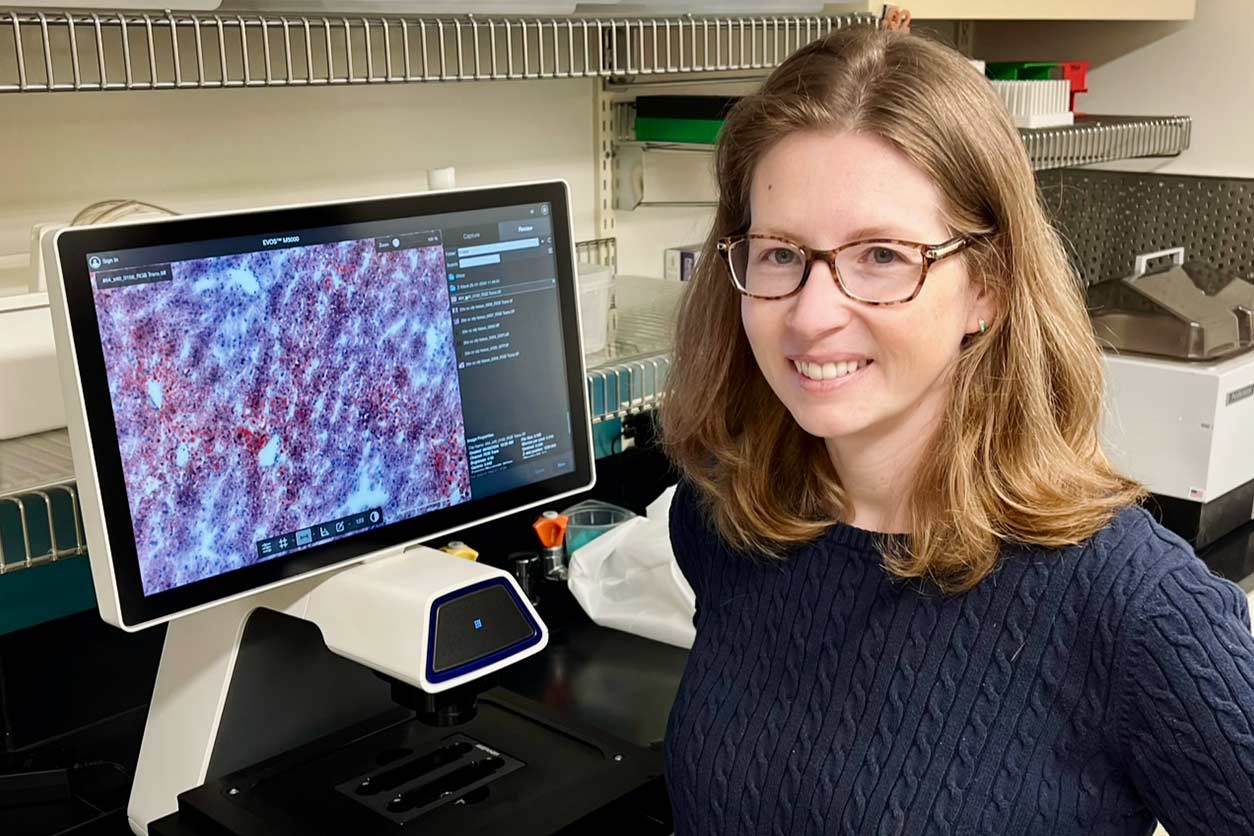 Colette Miller, Ph.D., standing in front of a computer screen.