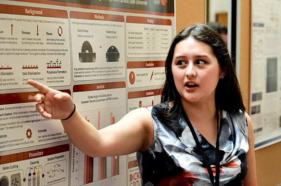 Cordelia McKelvy standing in front of poster