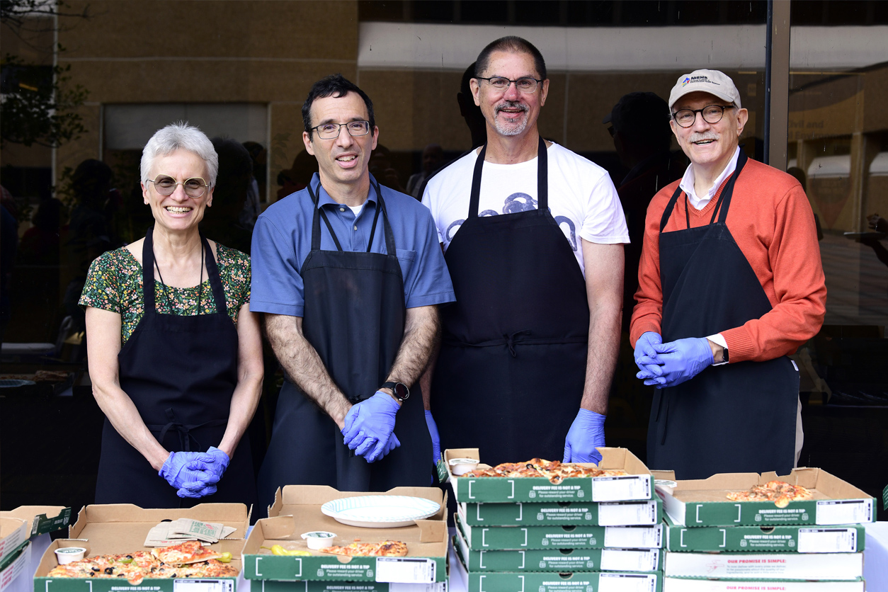 London, Fessler, Wade and Woychik handing out pizza