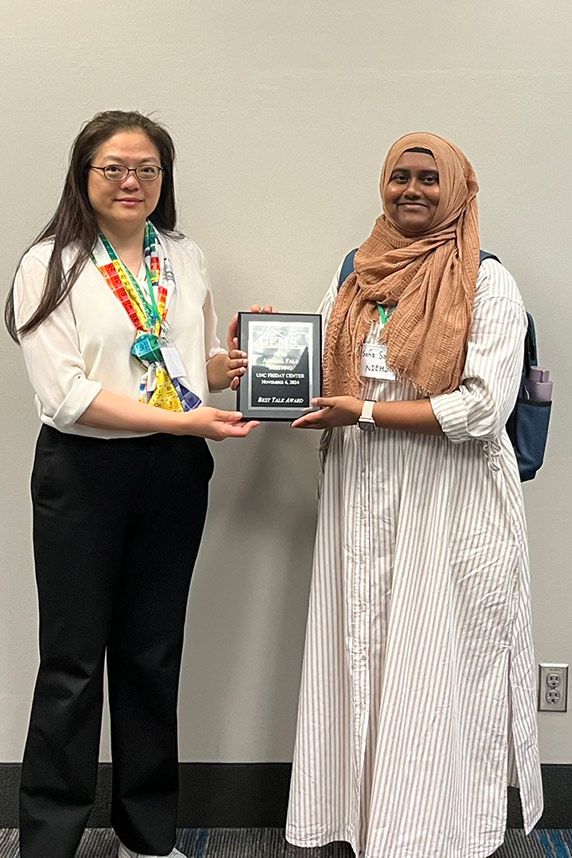 Amy Wang, Ph.D., president-elect of GEMS, left, presents Safia Sauty, Ph.D., an NIEHS trainee with the award for best oral presentation.