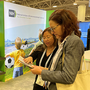 Virginia Matthews, left, of the NIEHS Office of Communications and Public Liaison (OCPL) explains institute programs to APHA attendees who stopped at the NIEHS exhibit booth.