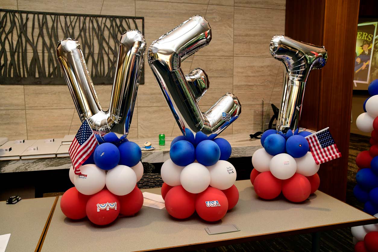 VET spelled out in silver balloons, with blue, white and red smaller circular balloons underneath.