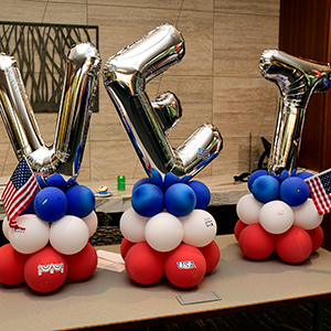 VET spelled out in silver balloons, with blue, white and red smaller circular balloons underneath.