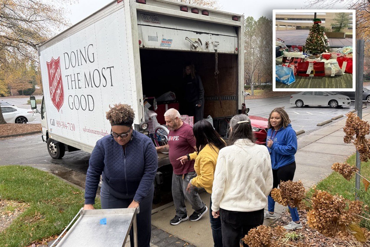 Team bringing boxes out of delivery truck - Christmas Tree with presents underneath