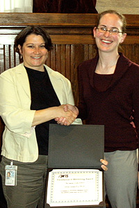 Orna Cohen-Fix, Ph.D., shakes hands with and receives a certificate of appreciation from AWIS board member Michelle Arnold, Ph.D.