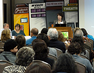Linda Birnbaum speaks at a podium in a crowded room.