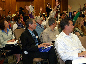 A group of audience members, some raising hands
